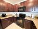 Close up of a kitchen with dark wood cabinets and stainless steel appliances at 11124 Leland Groves Dr, Riverview, FL 33579