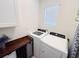 Functional laundry room with modern washer and dryer, cabinet storage, and a bright window at 11124 Leland Groves Dr, Riverview, FL 33579