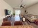 Comfortable living room featuring wood-look floors, a ceiling fan, a sofa, and sliding glass doors at 11124 Leland Groves Dr, Riverview, FL 33579