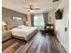 The main bedroom has a ceiling fan, hardwood floors, and a gray upholstered headboard at 11124 Leland Groves Dr, Riverview, FL 33579