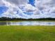 Scenic view of a tranquil pond surrounded by lush greenery and a beautiful sky at 11124 Leland Groves Dr, Riverview, FL 33579
