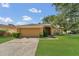 Charming single-story home featuring a lush green lawn and mature trees under a partly cloudy sky at 1236 Sweet Gum Dr, Brandon, FL 33511