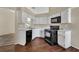 Kitchen area featuring black appliances, white cabinets, laminated flooring, and natural light at 1236 Sweet Gum Dr, Brandon, FL 33511