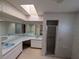 Bathroom with dual sinks, a skylight, a large mirror, and a glass-enclosed shower at 13382 Drummond Ave, Port Charlotte, FL 33953
