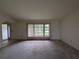 Living room featuring a large window, neutral walls, and carpet flooring at 13382 Drummond Ave, Port Charlotte, FL 33953