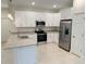 Modern kitchen featuring white cabinets, stainless steel appliances, granite countertops, and a center island at 5079 Fairlane Dr, North Port, FL 34288