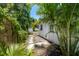 Lush backyard with tropical foliage, a storage shed, and a pathway leading to a serene outdoor space at 707 63Rd S Ave, St Petersburg, FL 33705