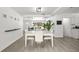 Open-concept dining area with white wood flooring and a view of the living room, great for entertaining and comfortable living at 707 63Rd S Ave, St Petersburg, FL 33705