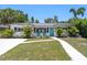 Charming home featuring a bright, welcoming teal door and complemented by neatly arranged landscaping and a well-maintained driveway at 707 63Rd S Ave, St Petersburg, FL 33705