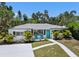 Charming home featuring a bright, welcoming teal door and complemented by neatly arranged landscaping and a well-maintained driveway at 707 63Rd S Ave, St Petersburg, FL 33705