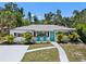 Charming home featuring a bright, welcoming teal door and complemented by neatly arranged landscaping and a well-maintained driveway at 707 63Rd S Ave, St Petersburg, FL 33705