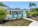 Front exterior of a home showcasing a turquoise door, fresh paint, and well-maintained landscaping at 707 63Rd S Ave, St Petersburg, FL 33705