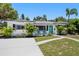 Charming single-story home with lush landscaping, a turquoise door, and a modern design at 707 63Rd S Ave, St Petersburg, FL 33705