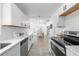 Updated Kitchen with stainless appliances, white cabinets and views into the dining area at 707 63Rd S Ave, St Petersburg, FL 33705