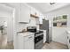 Well-lit kitchen with white cabinetry, stainless steel appliances, and sleek countertops at 707 63Rd S Ave, St Petersburg, FL 33705