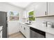 Clean kitchen featuring quartz countertops, white cabinets, and a stainless steel dishwasher at 707 63Rd S Ave, St Petersburg, FL 33705