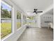 Sunroom with bright windows and modern vinyl flooring, seamlessly transitioning to dining area at 707 63Rd S Ave, St Petersburg, FL 33705