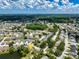 Aerial view of community with tree coverage, lake, community center, and residential streets at 7728 Balharbour Dr, New Port Richey, FL 34653