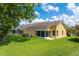 Backyard of home featuring lush green grass and screened in lanai at 7728 Balharbour Dr, New Port Richey, FL 34653