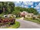 Exterior view of the community clubhouse with landscaped entrance and ample parking at 7728 Balharbour Dr, New Port Richey, FL 34653