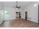 Inviting living room featuring hardwood floors, large windows, and access to a screened-in porch at 7728 Balharbour Dr, New Port Richey, FL 34653