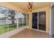 Enclosed sunroom with view of lake, tile floors, and open doorway to interior space at 7728 Balharbour Dr, New Port Richey, FL 34653
