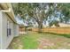 Spacious backyard with a covered patio, mature trees, and a privacy fence at 837 Greenbelt Cir, Brandon, FL 33510