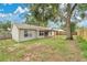 View of the home's backyard, with a patio and large tree at 837 Greenbelt Cir, Brandon, FL 33510