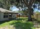 View of a backyard with a patio, lush green grass, and a wood privacy fence at 837 Greenbelt Cir, Brandon, FL 33510