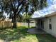 View of backyard featuring a covered patio, lush green grass, and fenced yard at 837 Greenbelt Cir, Brandon, FL 33510