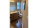 Well-lit bathroom features double sinks, laminate counters, and wood-look floors at 837 Greenbelt Cir, Brandon, FL 33510