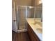 Bathroom with double sinks, walk-in shower and wood-look floors at 837 Greenbelt Cir, Brandon, FL 33510
