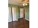 Bedroom with green accent wall, ceiling fan, closet, and wood floor at 837 Greenbelt Cir, Brandon, FL 33510