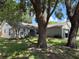 Charming home featuring mature trees, neutral siding, shutters, and an attached garage at 837 Greenbelt Cir, Brandon, FL 33510