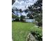 Expansive backyard featuring lush green grass, mature trees, and a white privacy fence at 4924 Creekside Trl, Sarasota, FL 34243