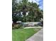 Community entrance to Carlyle at The Villages of Palm-Aire with lush landscaping and mature palm trees at 4924 Creekside Trl, Sarasota, FL 34243
