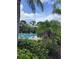 Community pool area surrounded by lush tropical greenery and lounge chairs at 4924 Creekside Trl, Sarasota, FL 34243