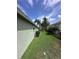 Well-maintained side yard with lush green grass and mature palm trees at 4924 Creekside Trl, Sarasota, FL 34243
