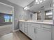 Bathroom boasts double vanity, sleek cabinets, modern fixtures, and views to bedroom and lakeside at 6256 Baywood Ct, Bradenton, FL 34211