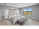 Bright bedroom featuring a tufted headboard, bench seat, and serene views from the double windows at 6256 Baywood Ct, Bradenton, FL 34211