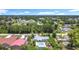An aerial view of a light blue home with a pool in a sunny neighborhood with green tree coverage at 7341 Hart St, Englewood, FL 34224