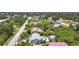 An aerial view of a home with a pool in a sunny residential neighborhood, including lush greenery and tree coverage at 7341 Hart St, Englewood, FL 34224