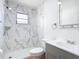Modern bathroom featuring a tub with marble-style tile surround and updated vanity at 7341 Hart St, Englewood, FL 34224