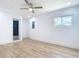 Bedroom featuring modern ceiling fan, light wood floors, and bathroom access at 7341 Hart St, Englewood, FL 34224