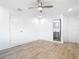 Bright bedroom offers light wood floors, ceiling fan, and en-suite bathroom at 7341 Hart St, Englewood, FL 34224