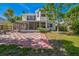Spacious backyard featuring a checkerboard patio, screened-in porch, and ample green space for outdoor enjoyment at 7716 Nottinghill Sky Dr, Apollo Beach, FL 33572