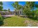 Expansive backyard with a brick patio and screened-in porch, framed by lush greenery at 7716 Nottinghill Sky Dr, Apollo Beach, FL 33572