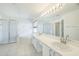 Spacious bathroom featuring dual sinks, a soaking tub, and a glass-enclosed shower at 7716 Nottinghill Sky Dr, Apollo Beach, FL 33572
