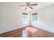 This bedroom features hardwood floors, two windows, and a ceiling fan at 7716 Nottinghill Sky Dr, Apollo Beach, FL 33572