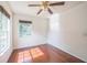 Bedroom featuring hardwood floors, two windows, and a ceiling fan at 7716 Nottinghill Sky Dr, Apollo Beach, FL 33572